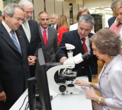 Doña Sofía observa unas muestras en el microscopio ante la atenta mirada de la ministra de Sanidad, Servicios Sociales e Igualdad, Ana Mato